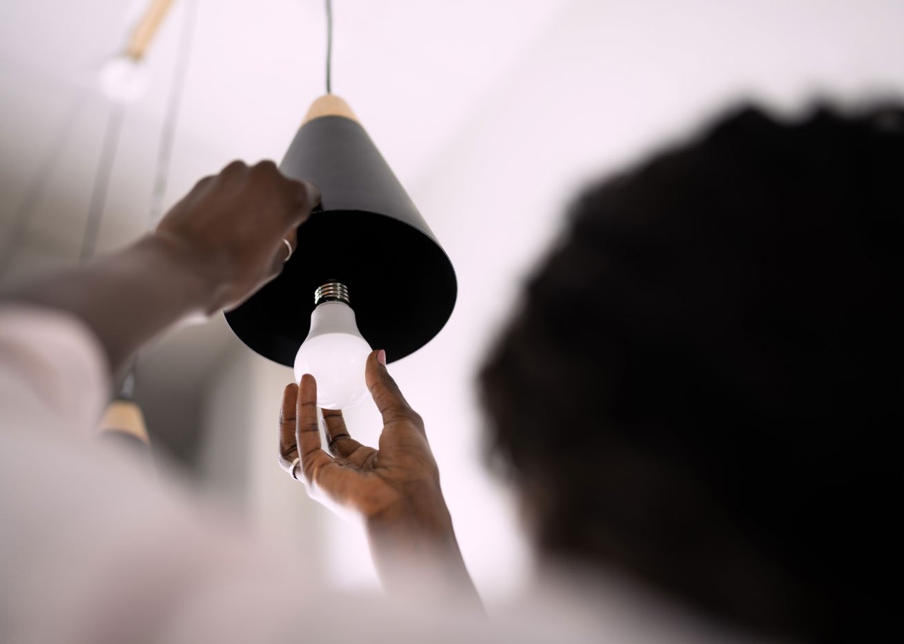 person replacing LED lightbulb